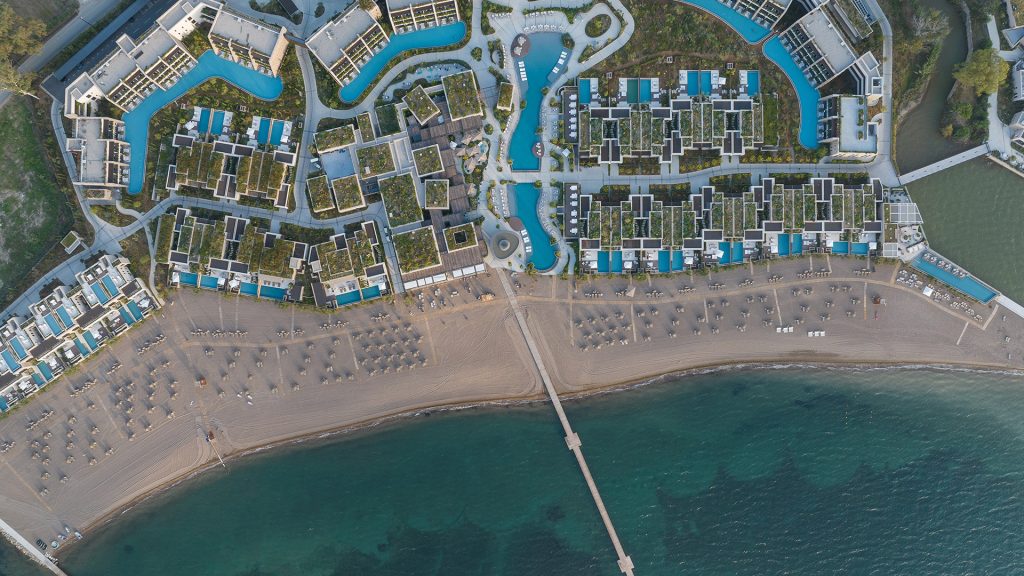 Aerial view of a luxury beachfront resort in Greece with conference facilities, pools, and meeting spaces by Lamda Development.