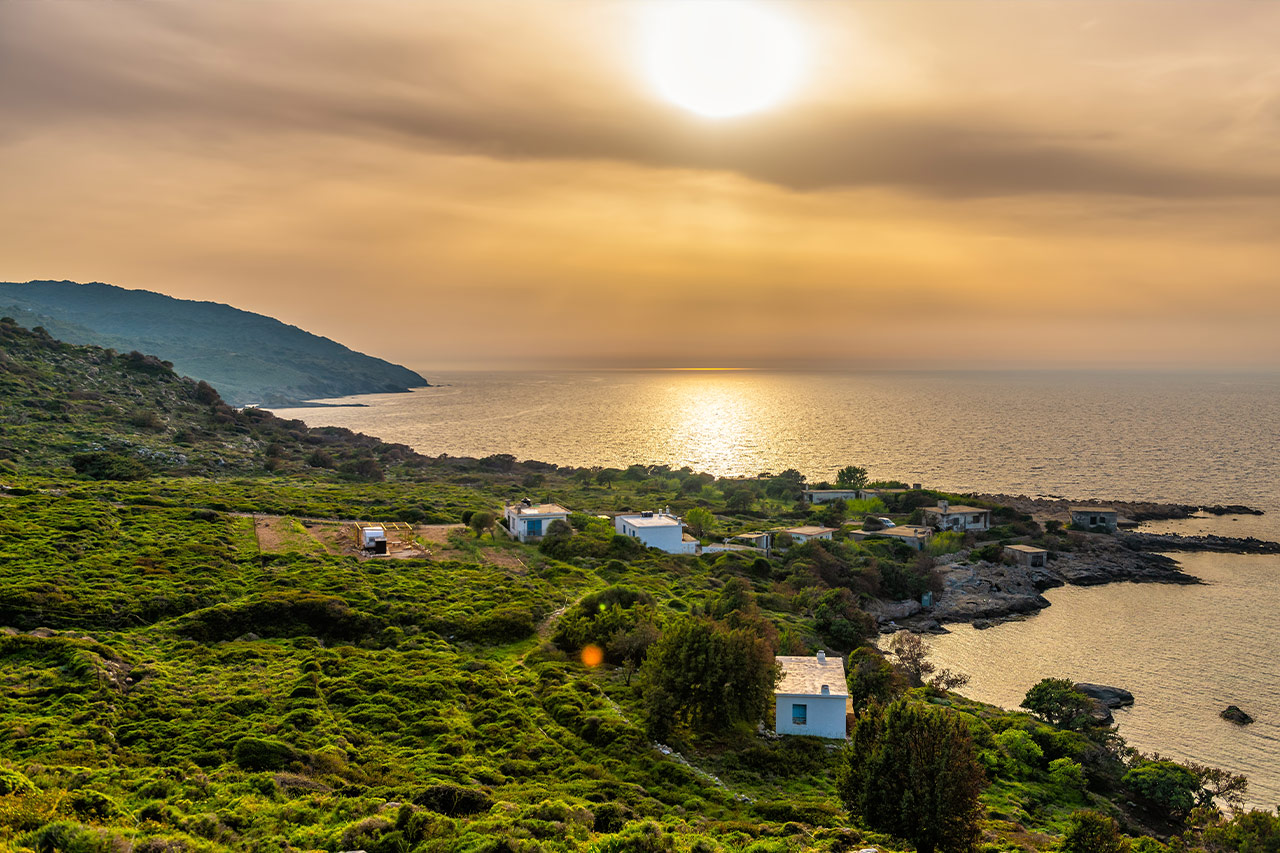 Peaceful coastal landscape in Ikaria, Greece, at sunset, known as a Blue Zone island of longevity and wellness.