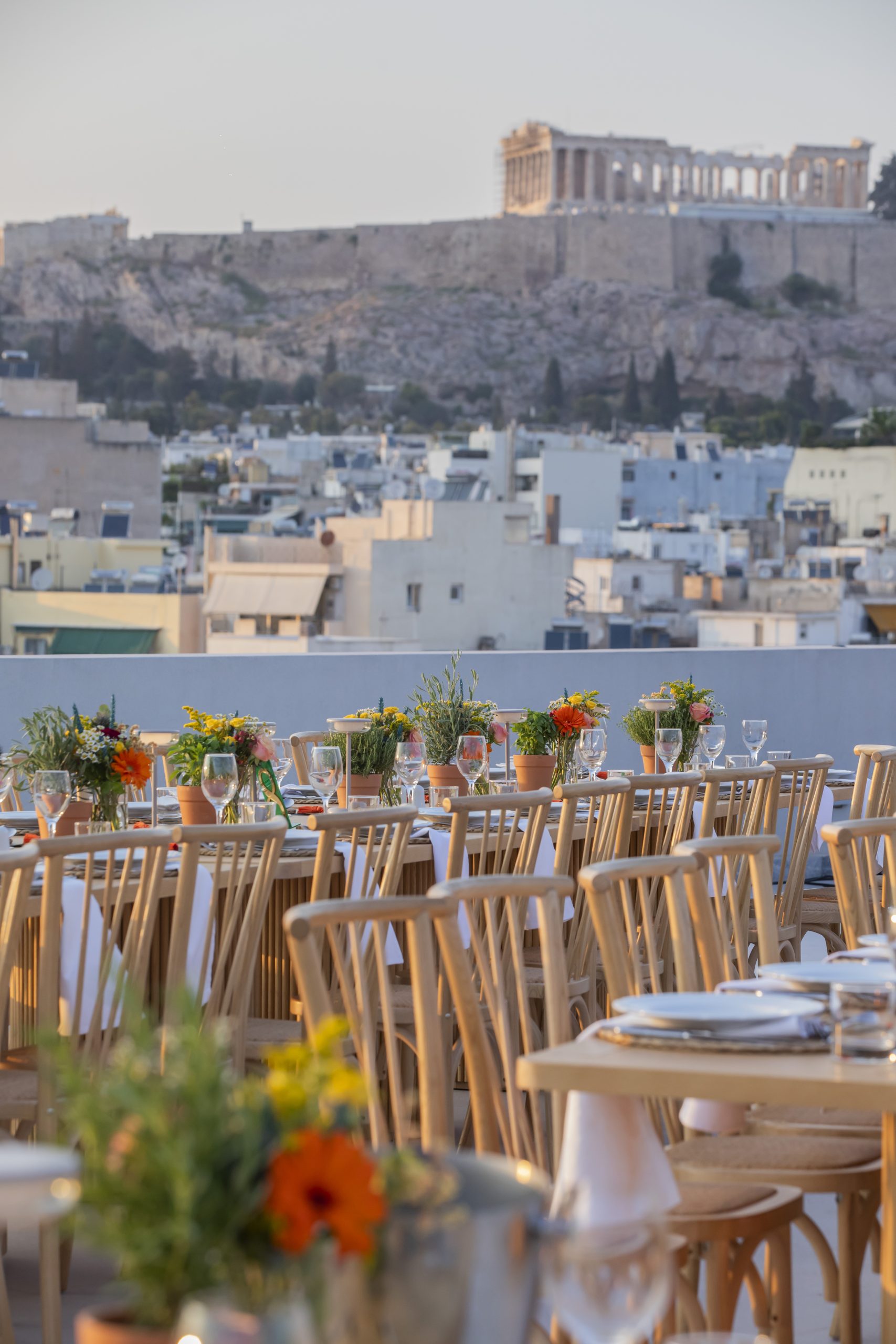 Rooftop dinner in Athens with elegant table setting and panoramic view of the Acropolis