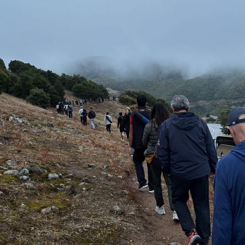 Participants hiking through misty Meteora landscapes during the EO Generational Leadership Program, reflecting teamwork and leadership under challenge.