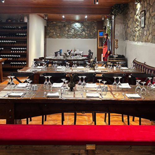 Rustic wine cellar dinner setup in Meteora, long wooden tables prepared for a private leadership gathering and shared reflection.