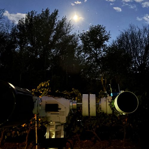 Stargazing telescopes set among vineyards at night, offering a reflective closing moment during a private leadership retreat in Meteora.