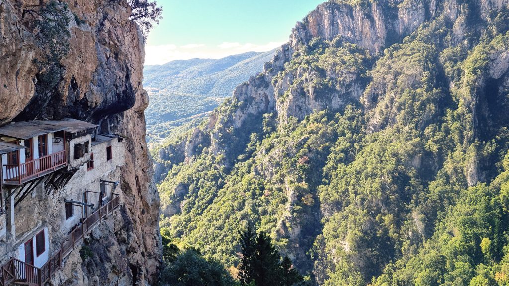 Mountain landscape view during Aquarius season featuring cliffside architecture and expansive natural scenery