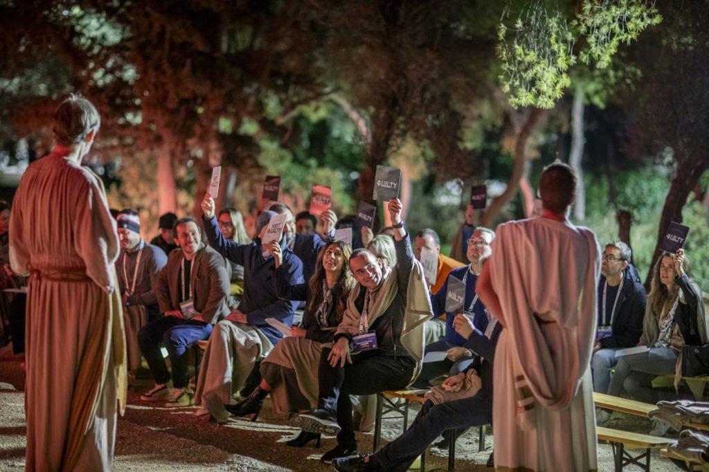 YPO Greater Europe members voting during the immersive Trial of Socrates experience at the Prison of Socrates in Athens.
